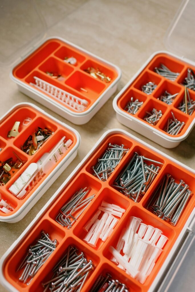 Neatly arranged hardware supplies in divided boxes for DIY projects.